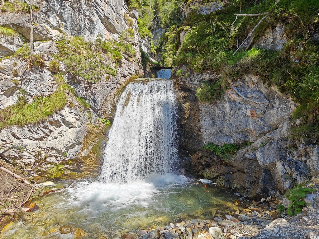 Moosbewachsene Felsen säumen den versteckten Wasserfall in Salzburgs kleinster Gemeinde.
